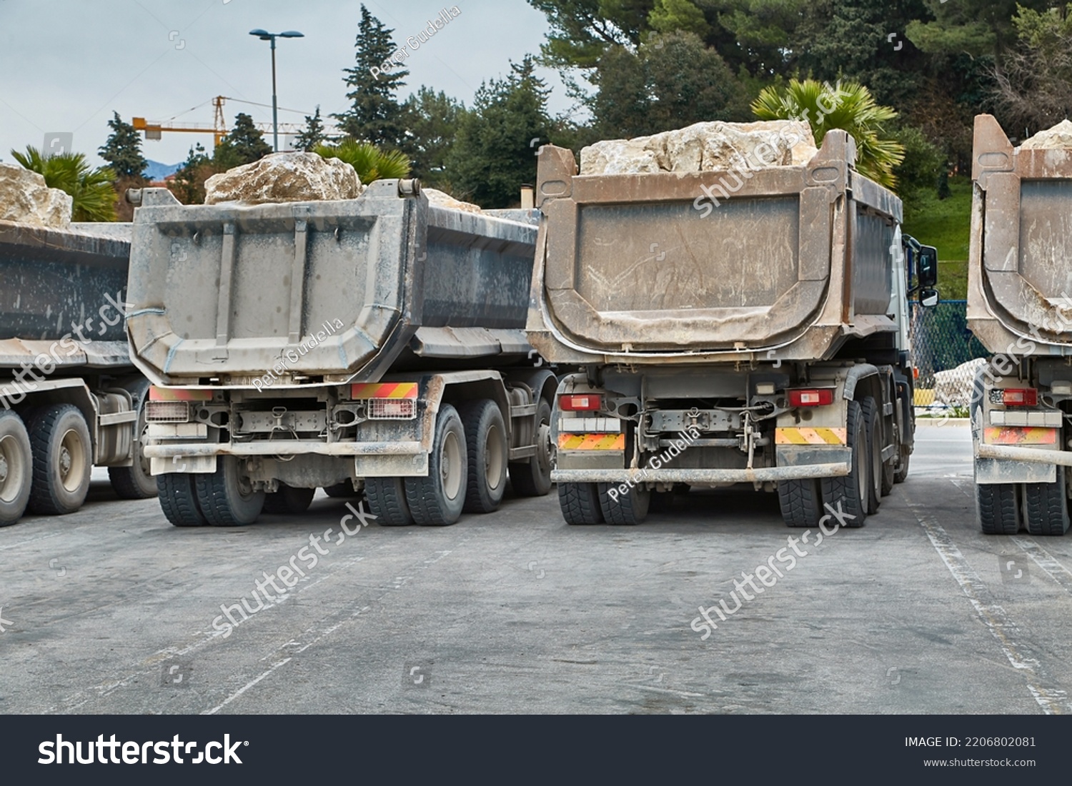 Dump Trucks at a road construction site carrying heavy boulders #2206802081