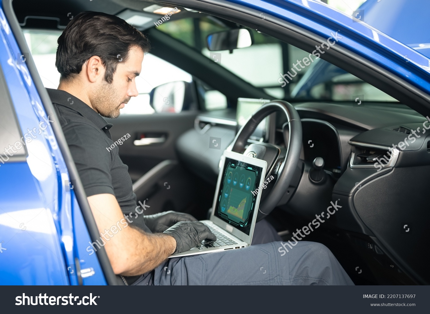Mechanic AsianArab man using laptop computer examining tuning fixing repairing car engine automobile vehicle parts using tools equipment in workshop garage support service in overall work uniform #2207137697