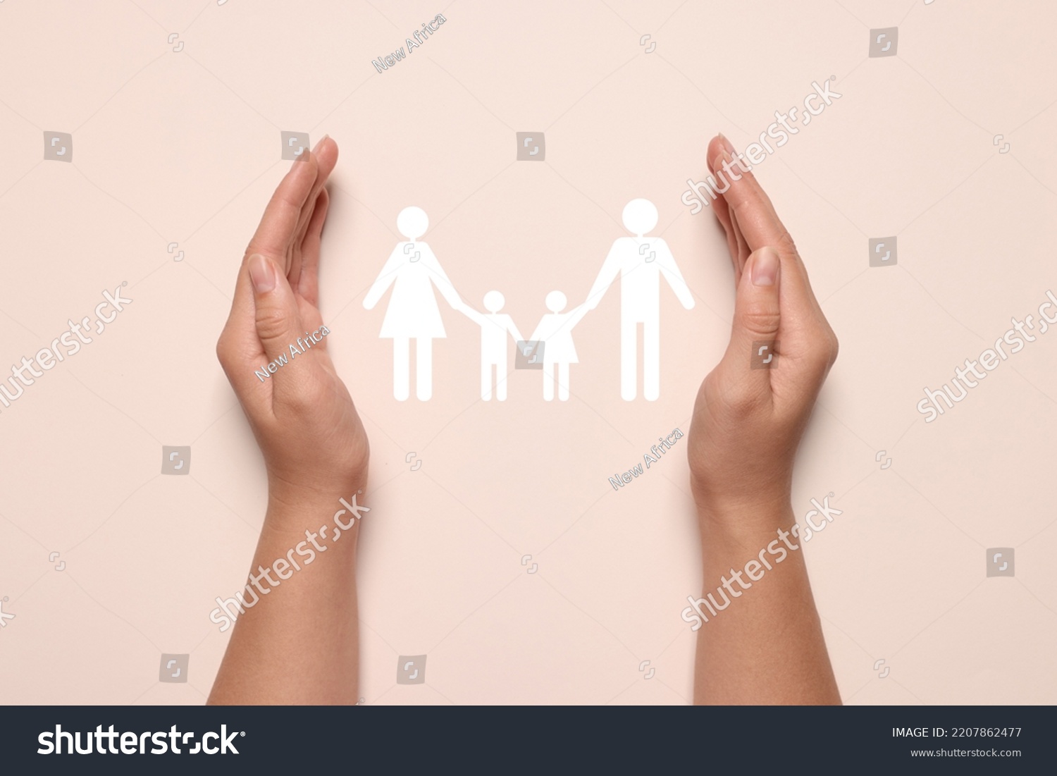 Woman holding hands around paper silhouette of family on light pink background, top view. Insurance concept #2207862477