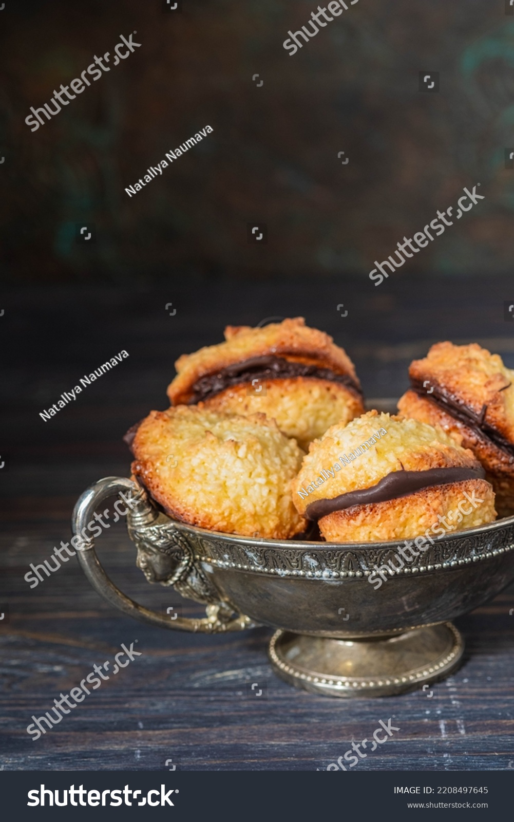 Dessert, coconut cookies with dark chocolate in a vintage metal vase on a dark background. Cookie recipes. English cuisine #2208497645