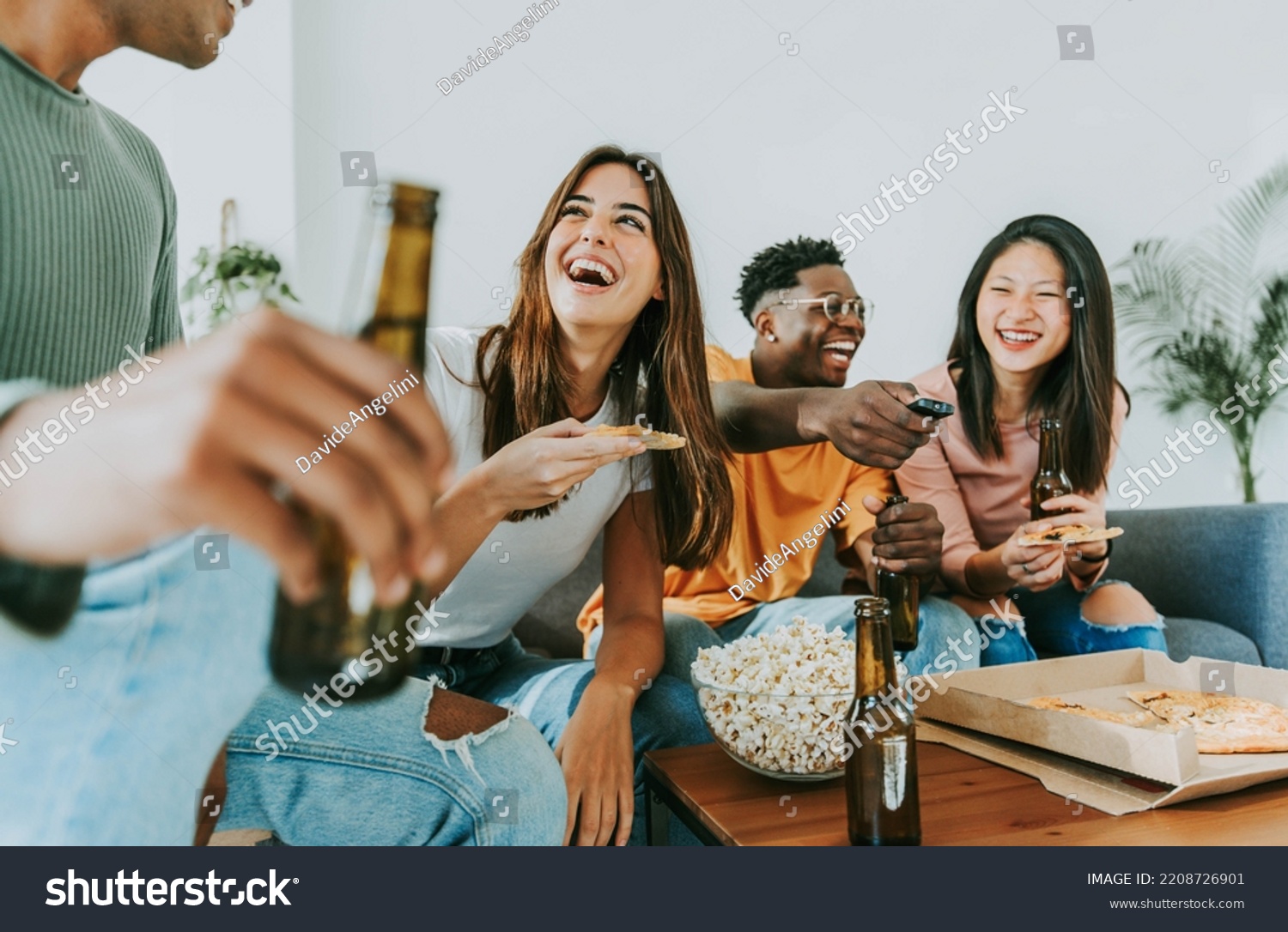 Group of friends watching tv and eating pizza - Multiracial cheerful young people having weekend home party together - Happy students having fun in university rooms - Youth lifestyle and food concept #2208726901