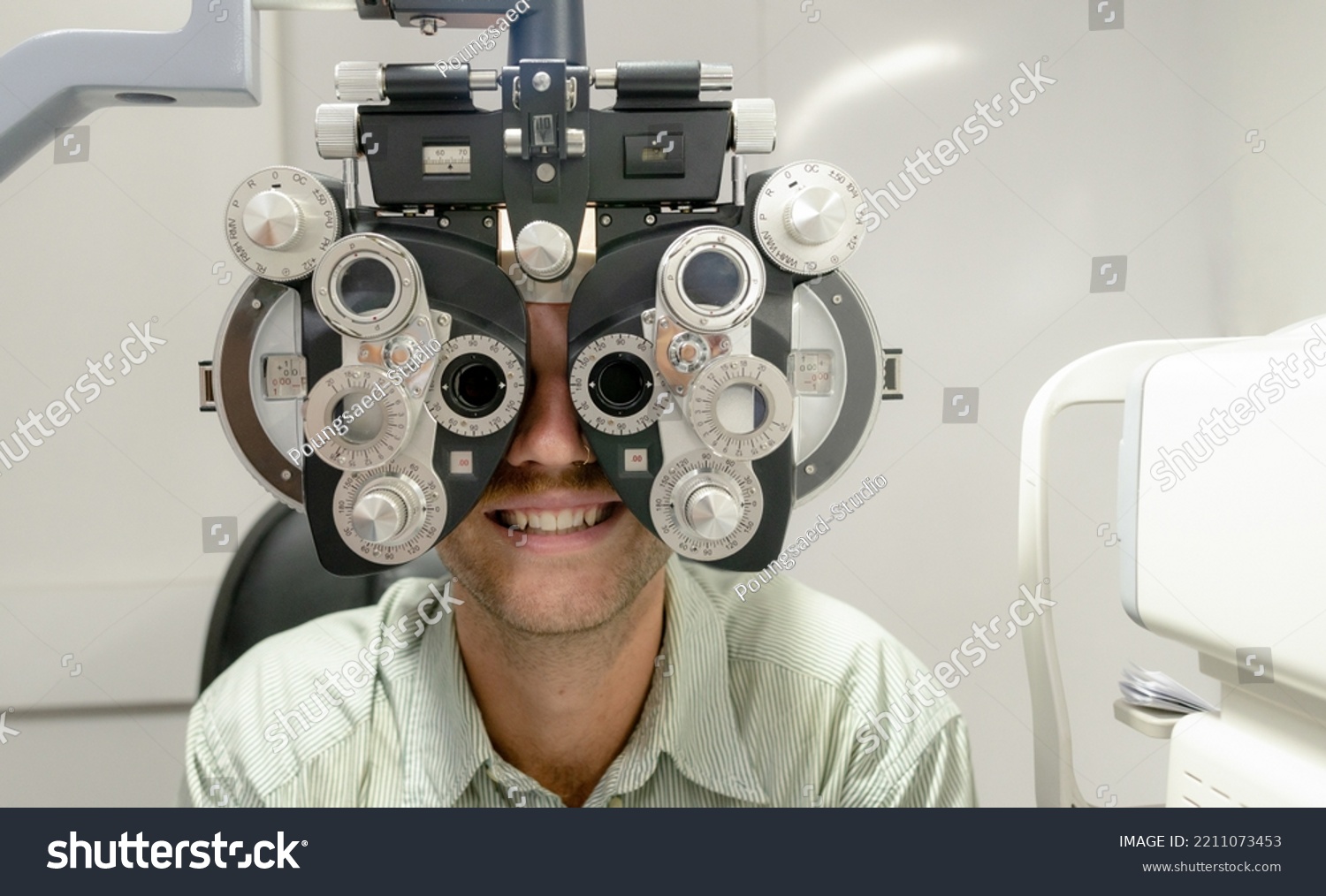 Young man examining eyes with optometrist to make glasses, professional eye exam, close-up shot at optometrist, health concept. #2211073453