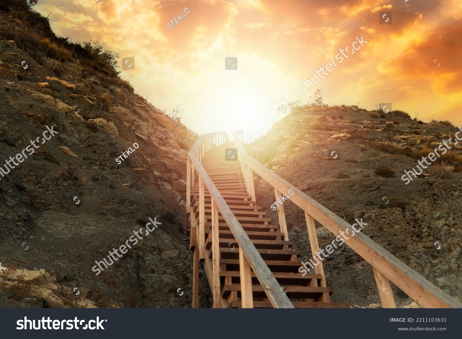 Religion and motivation. A wooden steep staircase in the mountain leading to the sky, with bright sunlight and sunset. Bottom view. The concept of paradise, victory and hope for a bright future. #2211103631