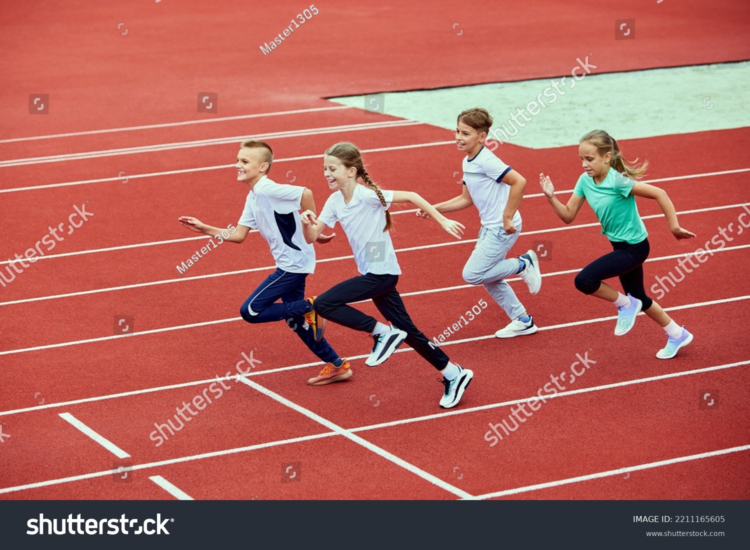 Group of children running on treadmill at the stadium or arena. Little fit boys and girls in sportswear training as athletes outdoor. Concept of sport, fitness, achievements, studying, goals, skills #2211165605