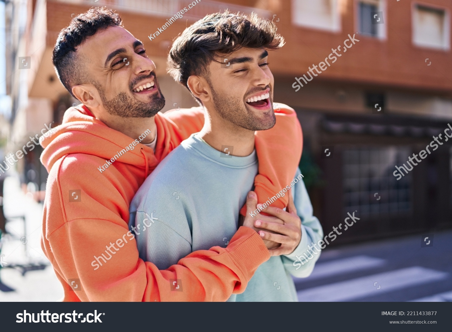 Two man couple hugging each other standing at street #2211433877