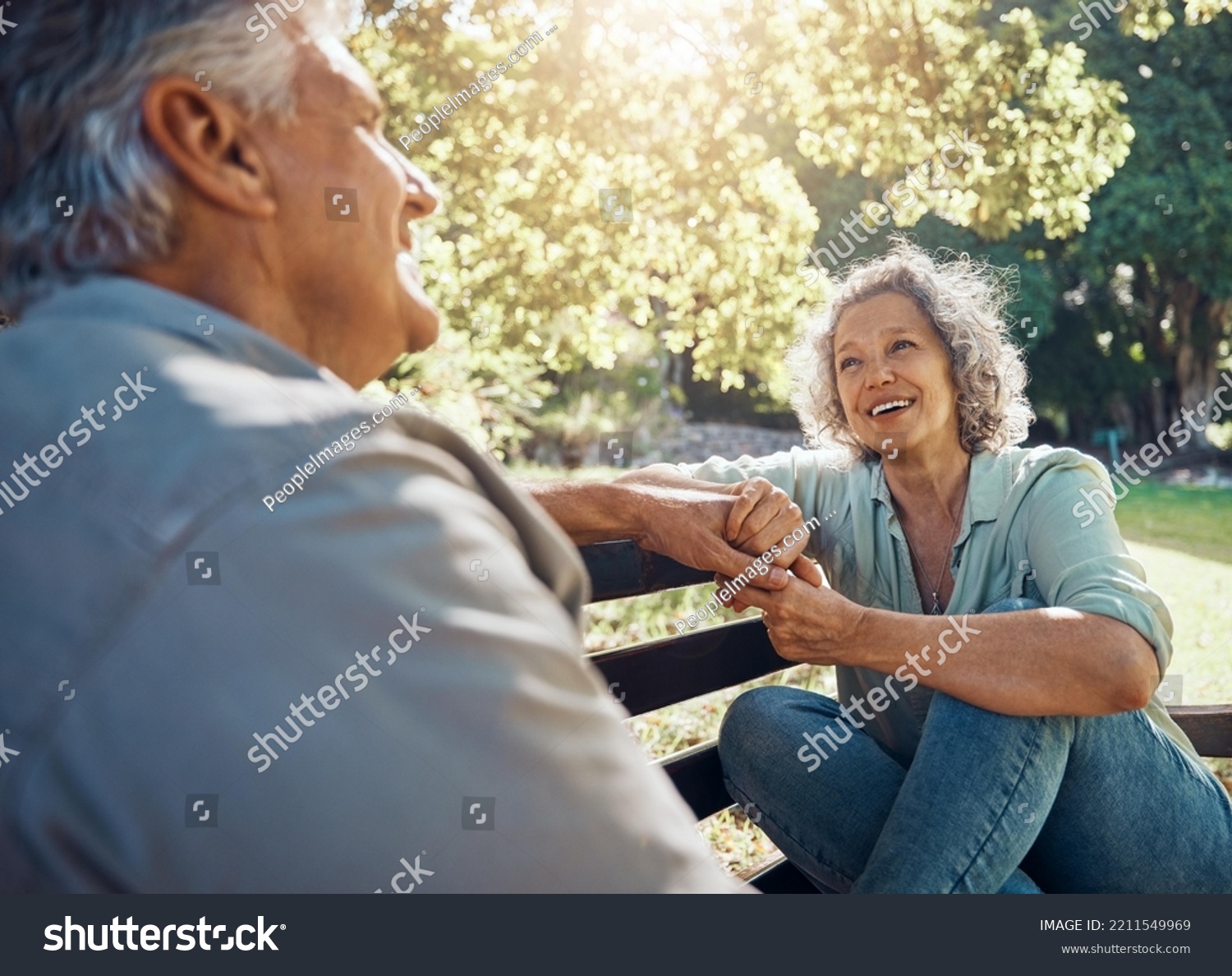 Elderly, couple and happy on bench in garden for conversation, bonding and happiness by trees in summer. Man, woman and retirement show love, relax and smile together in nature with sunshine at park #2211549969