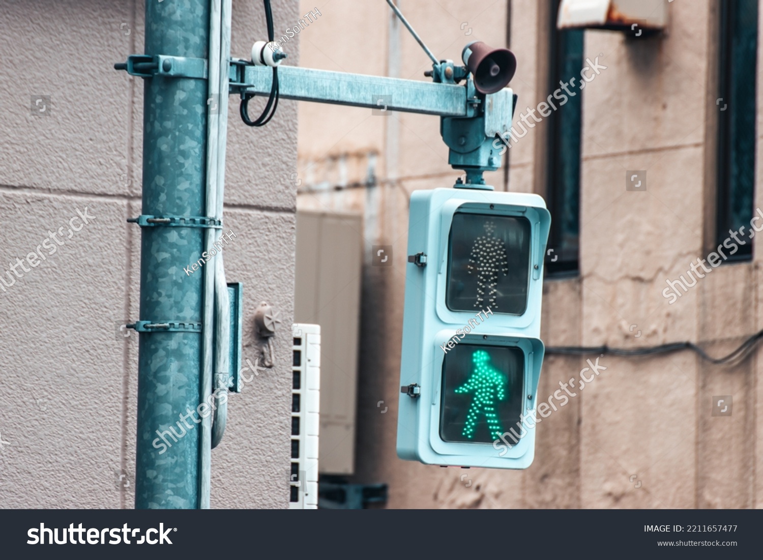 Close up of green Japanese pedestrian traffic light to warn pedestrian that it's not safe to cross the street. #2211657477