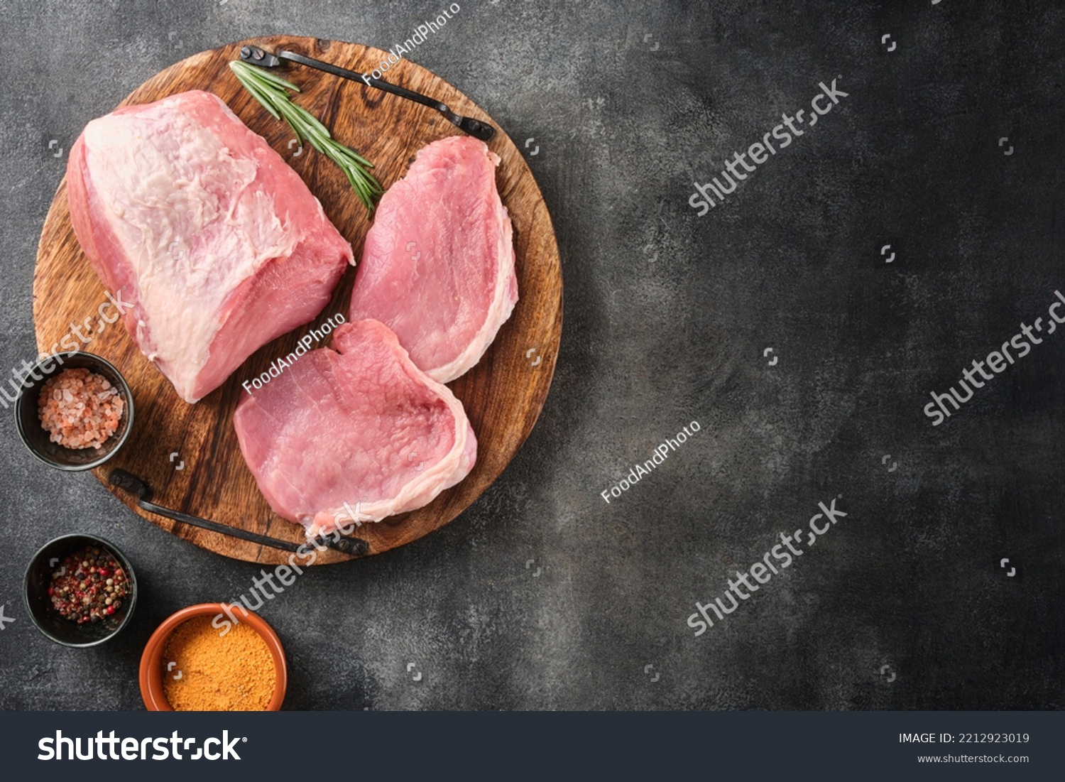 Raw pork meat on wooden board on grey background  with rosemary, salt and pepper. Pork loin. Copy space. Top view. #2212923019
