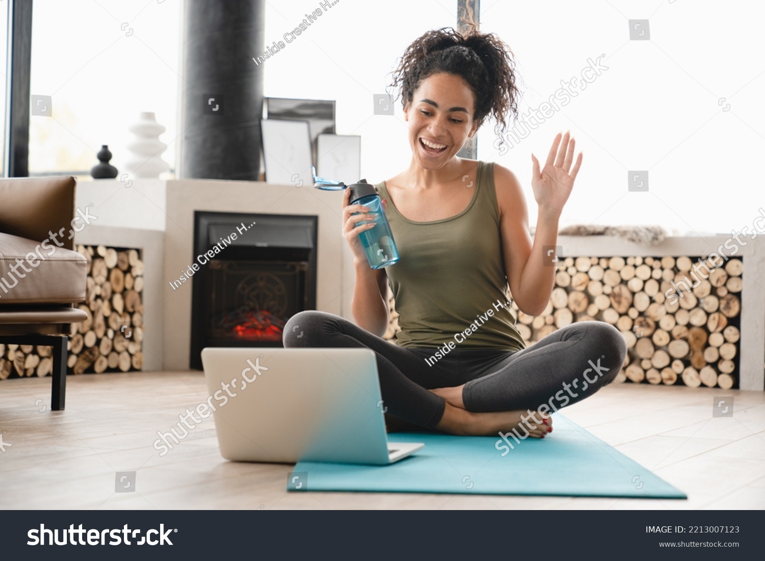 Online vlogging blogging training on fitness mat on laptop. African young female athlete doing yoga exercises at home, having videocall, video tutorial #2213007123