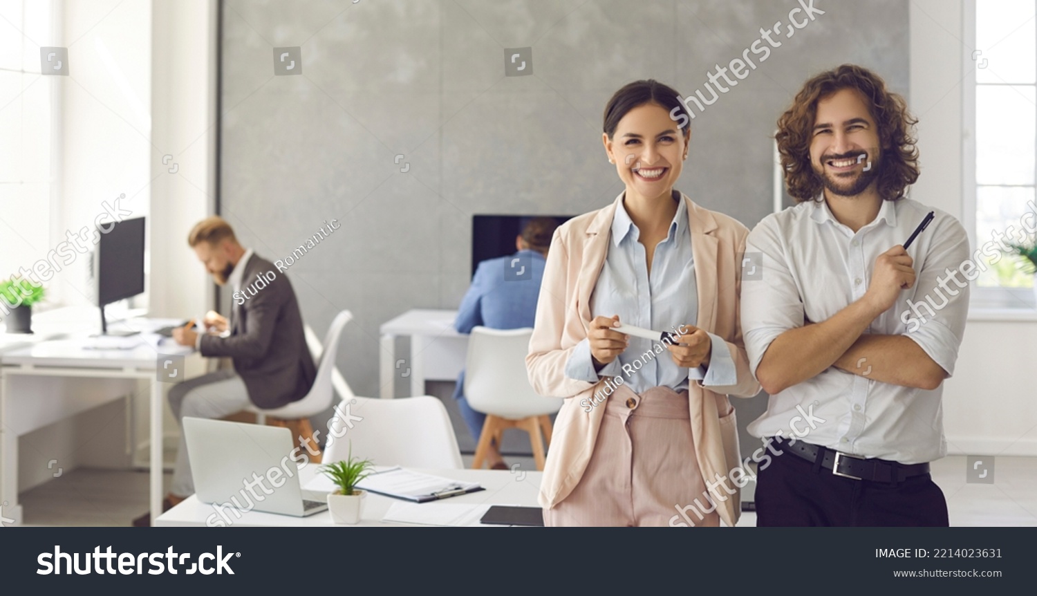 Happy smiling young business people in modern office workplace. Banner background with portrait of two satisfied successful colleagues, team leaders, teammates, business partners and friends at work #2214023631