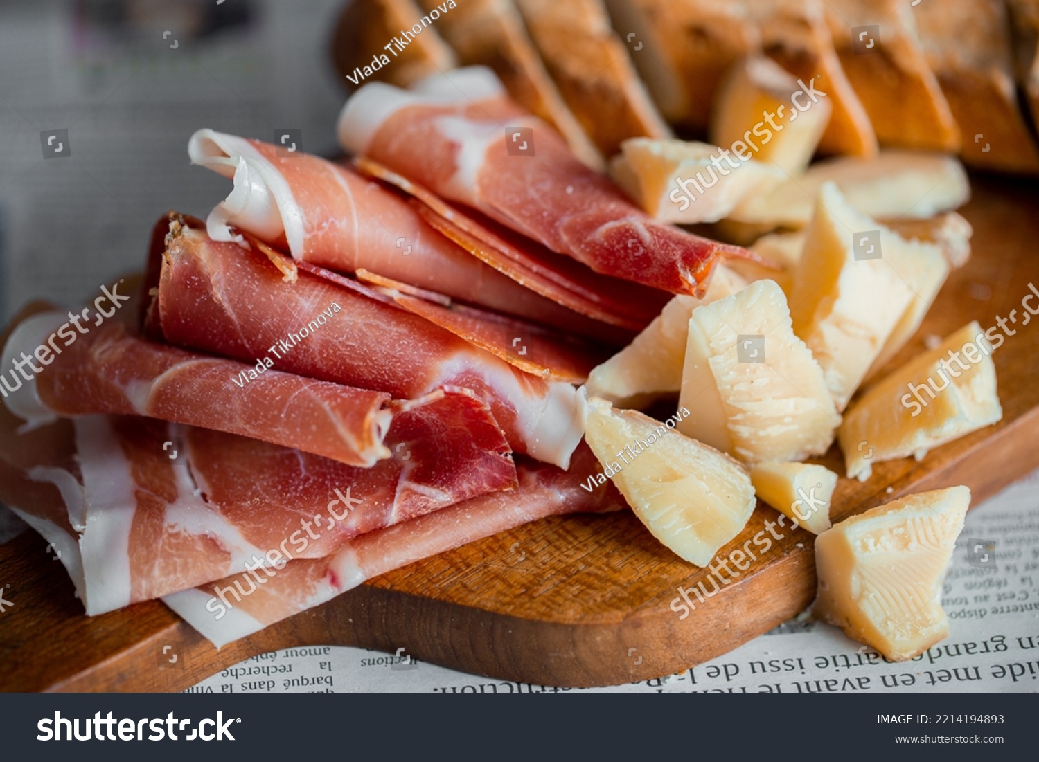Wooden board with cheese and ham. Board with jamon and cheese. Aperitif on the board. Jamon with bruschetta and parmesan.Delicious appetizer for wine.Italian appetizer. Jamon and salami with cheese. #2214194893