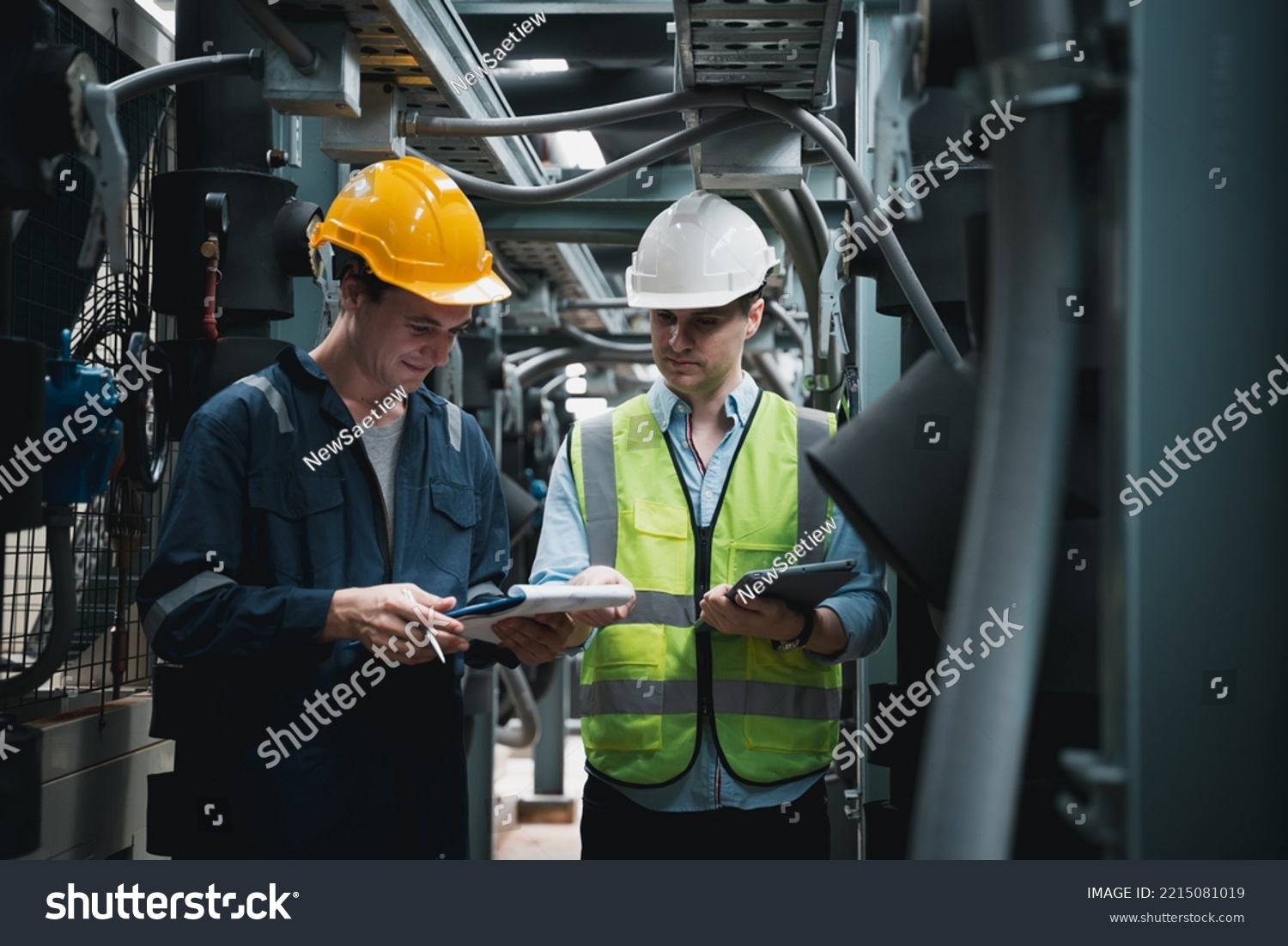 Engineer and team examining the air conditioning cooling system of a huge building or industrial site. #2215081019