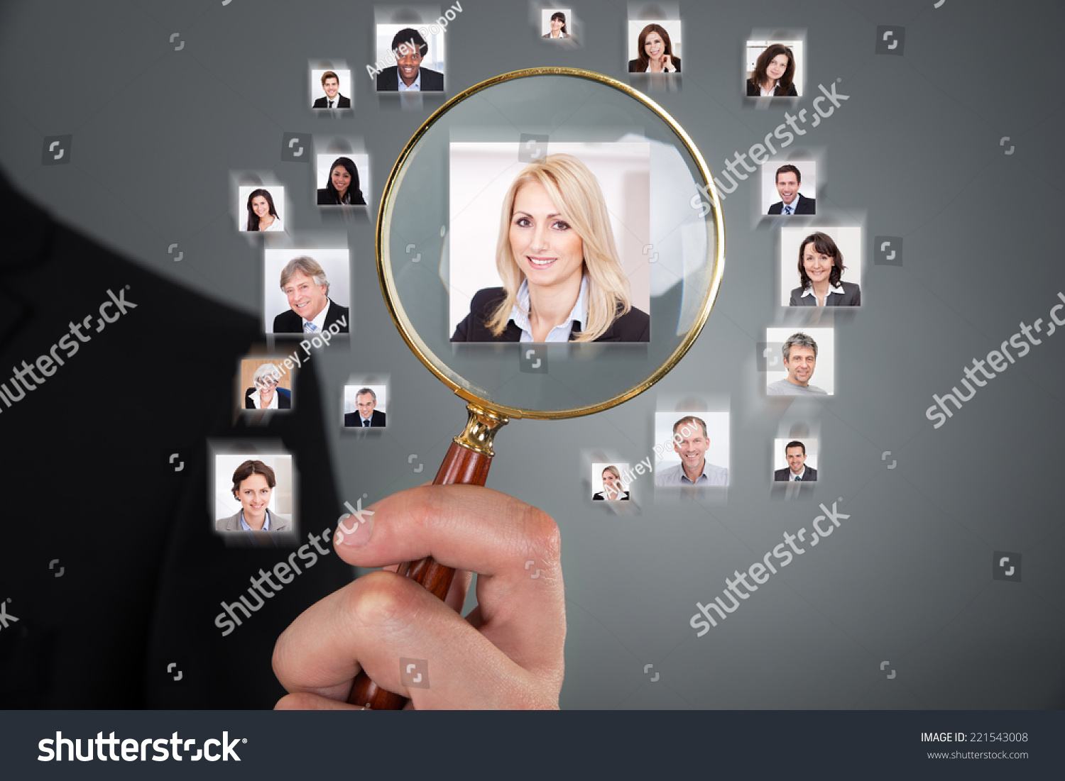 Cropped image of businessman searching candidate with magnifying glass over gray background #221543008