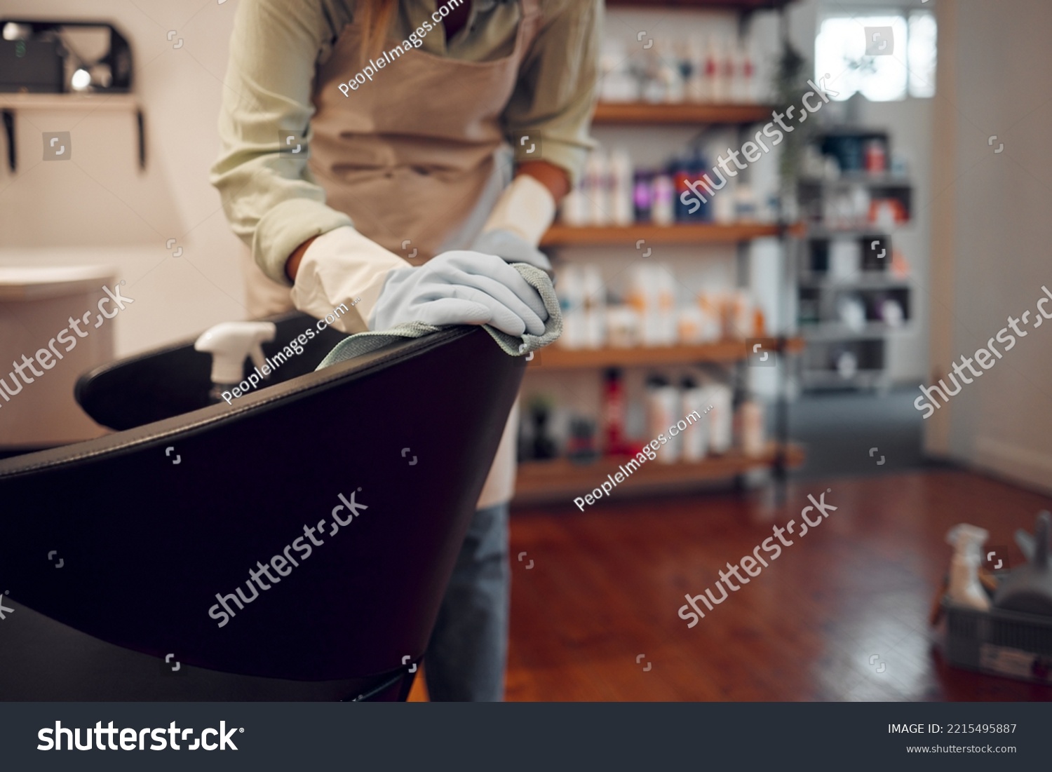 Salon, small business and woman cleaning chair with equipment in modern beauty parlor in city. Cleaner, maid or girl washing furniture at hairdressing shop with hygiene and sanitizing products. #2215495887