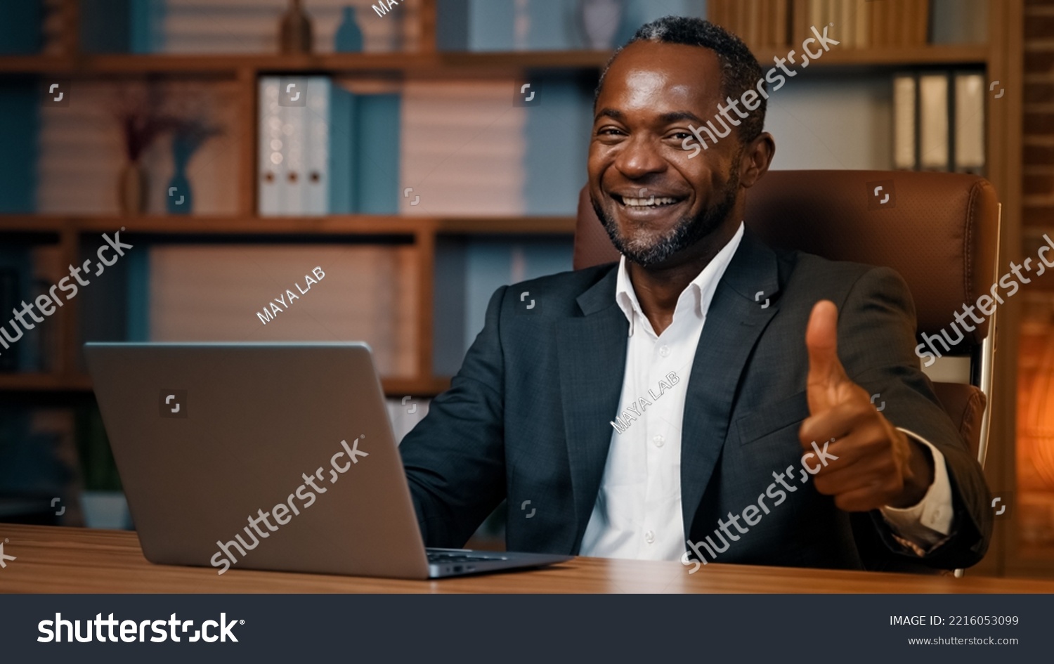 Focused man sitting at home office working on laptop successful businessman using new computer application for business tasks satisfied male customer showing thumb up gesture approval good result sign #2216053099