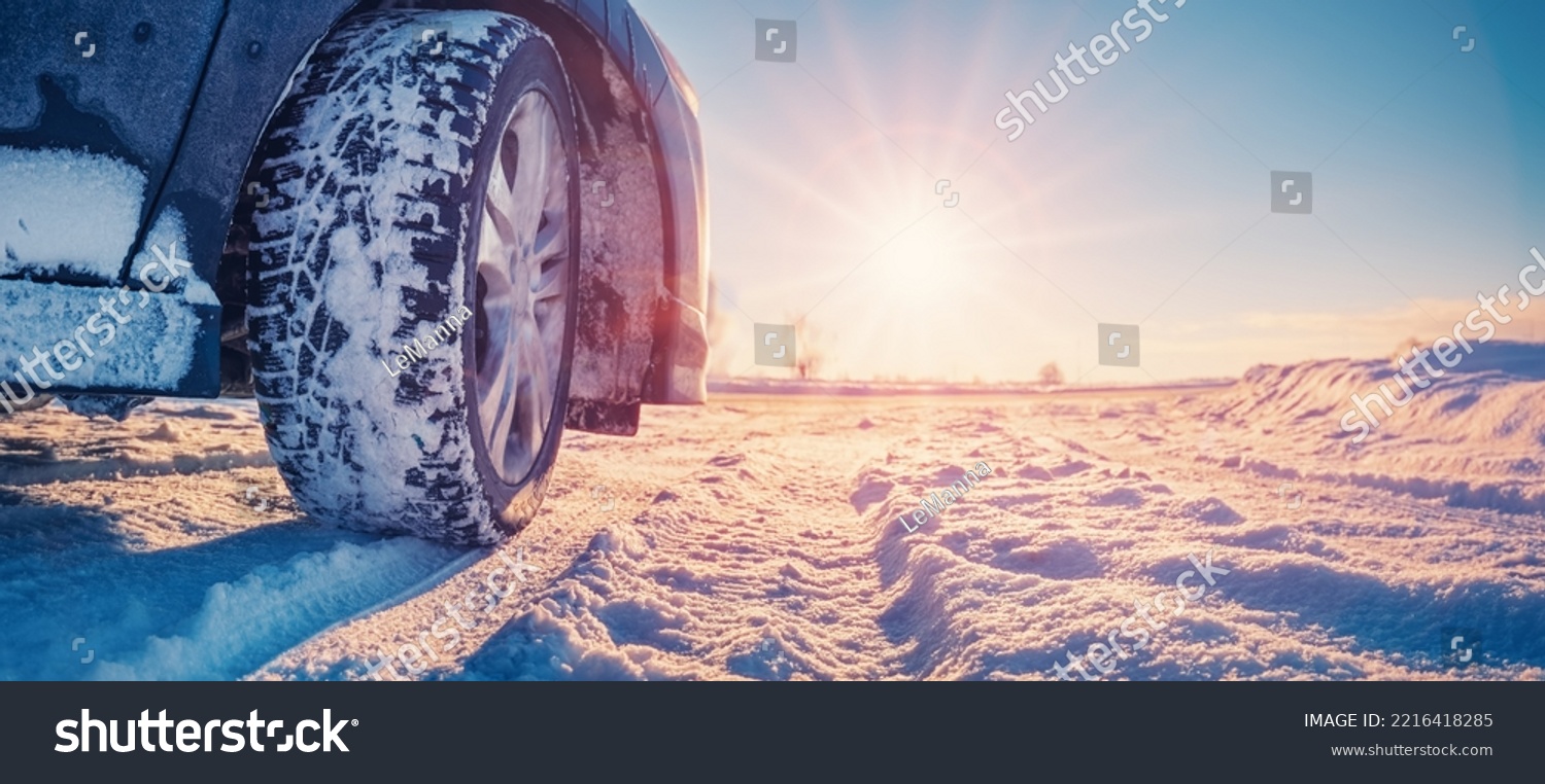 Closeup view of the car's wheel on the snowy road in natural park #2216418285