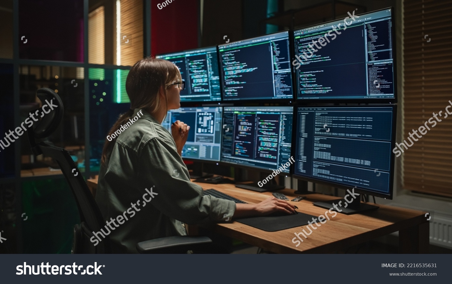 Cyber Security Agency: Female Programmer Coding on Desktop Computer With Six Displays in Dark Office. Caucasian Woman Monitors Data Protection System, Monitoring Information on SAAS Servers. #2216535631