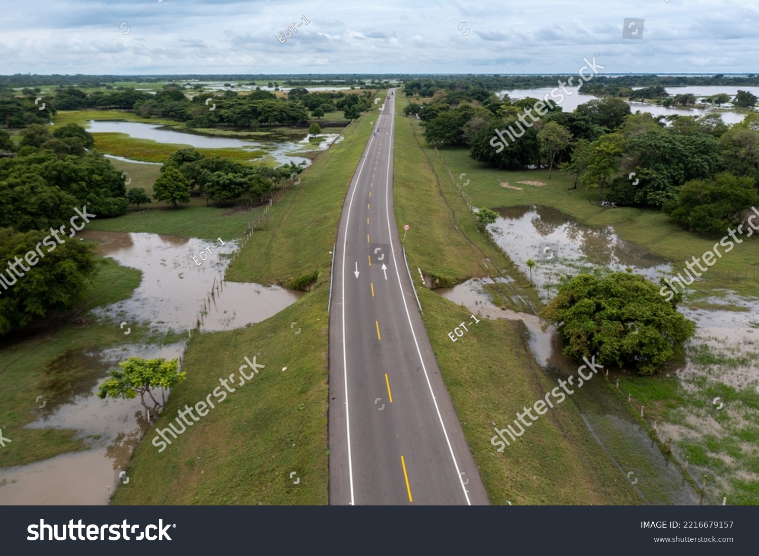Highway in a rural landscape flooded by proximity to the Magdalena River in the department of Bolivar. Colombia . #2216679157