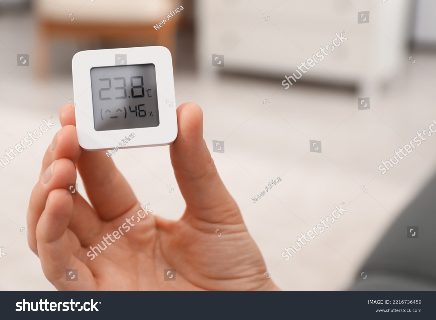 Woman holding digital hygrometer with thermometer at home, closeup. Space for text #2216736459