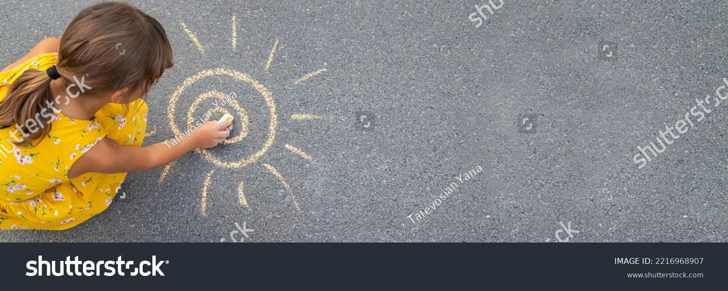 The child draws the sun on the asphalt. Selective focus. nature. #2216968907