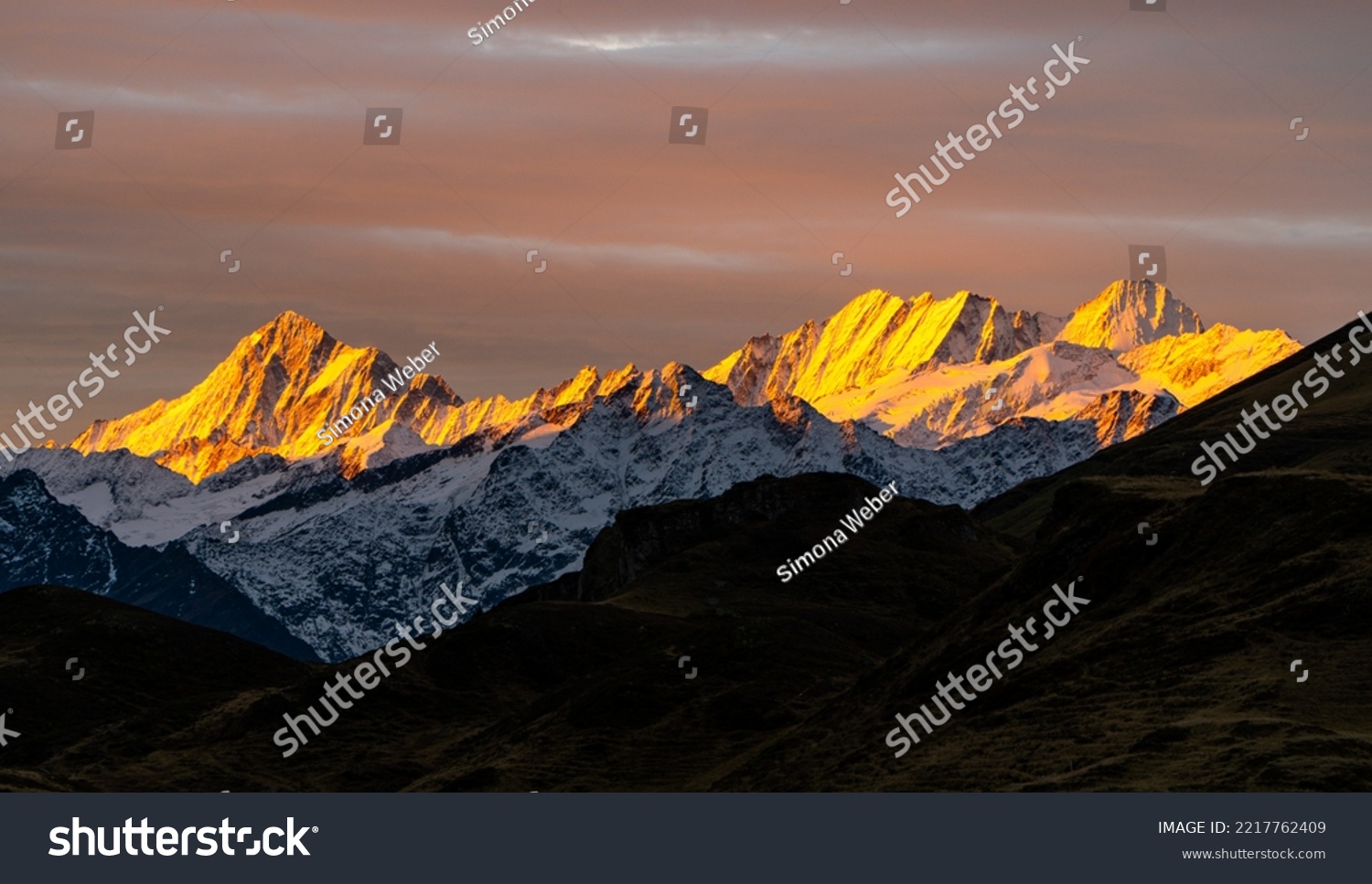 Sunrise with colourful snow peaks early morning in the Swiss alps, layers of mountains on a nice autumn day #2217762409