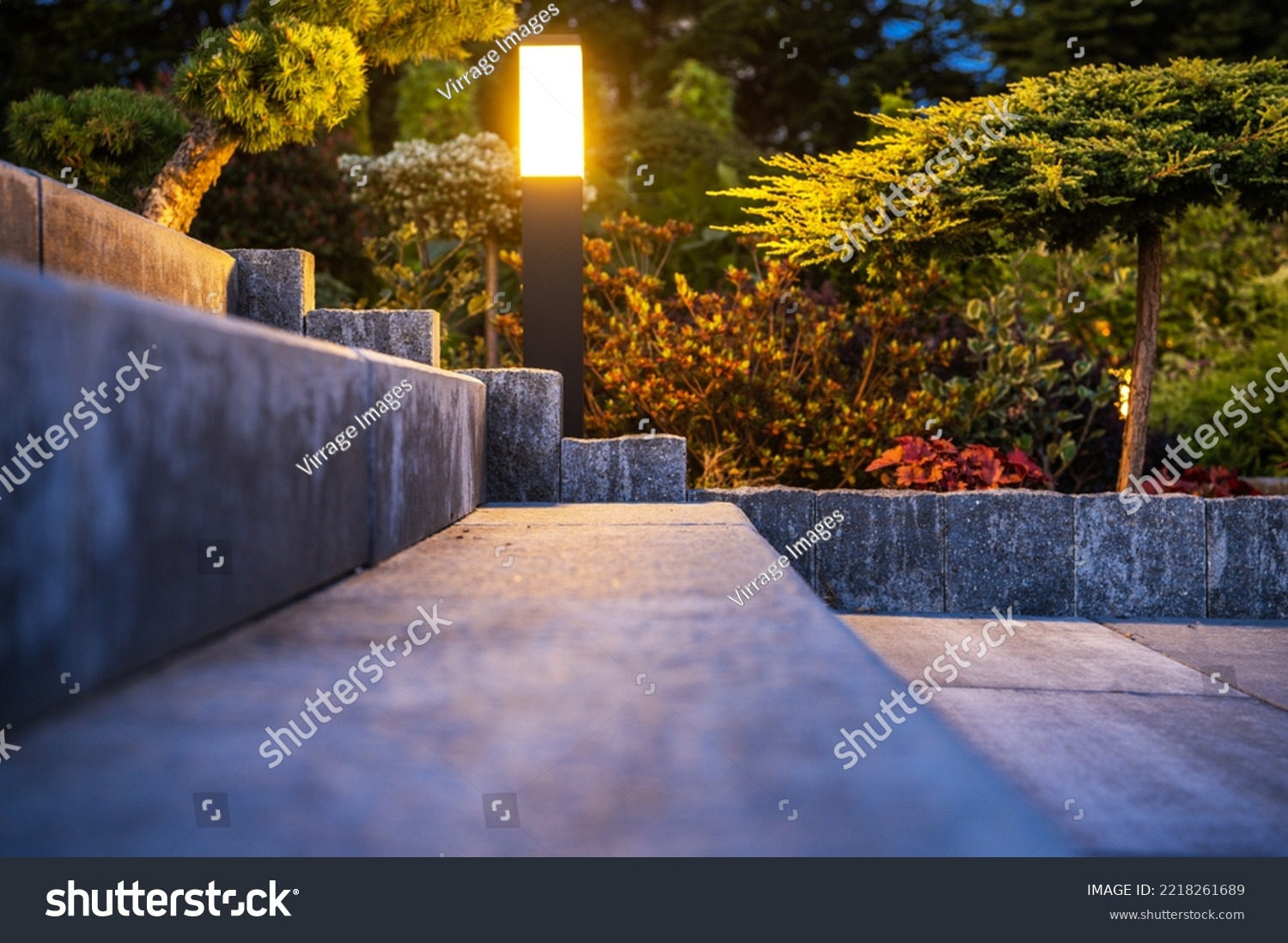 Outdoor Garden Light Installed Along Concrete Backyard Stairs Lighting Them Up in the Evening. Landscaped Garden in the Background. #2218261689