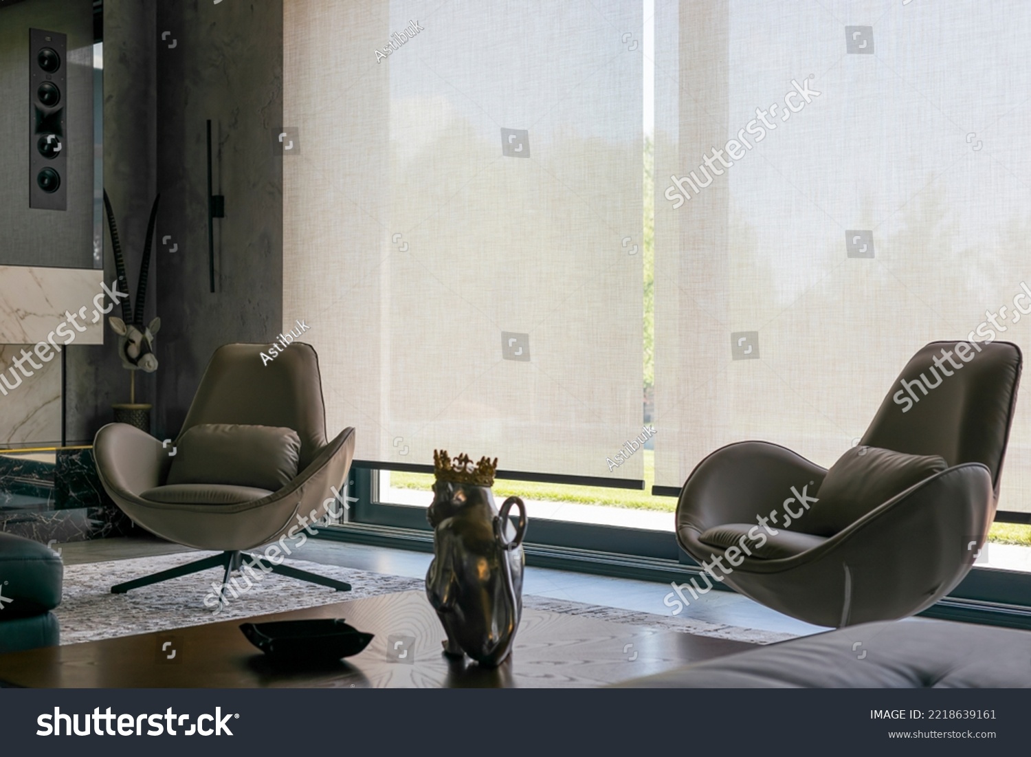 Interior design with roller blinds in the background. Automatic solar shades of large sizes on the window. Fabric with linen texture. In front of a large window is a chair on a carpet.  #2218639161