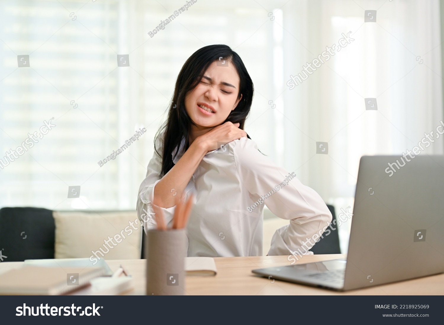 Beautiful young Asian businesswoman suffering from shoulders and back pain after had a long day at work. overworked, office syndrome concept #2218925069