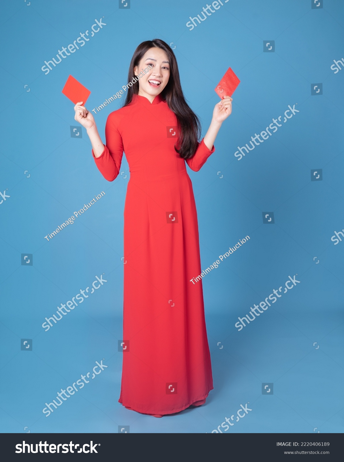 Full length image of young Vietnamese woman wearing red ao dai on background #2220406189