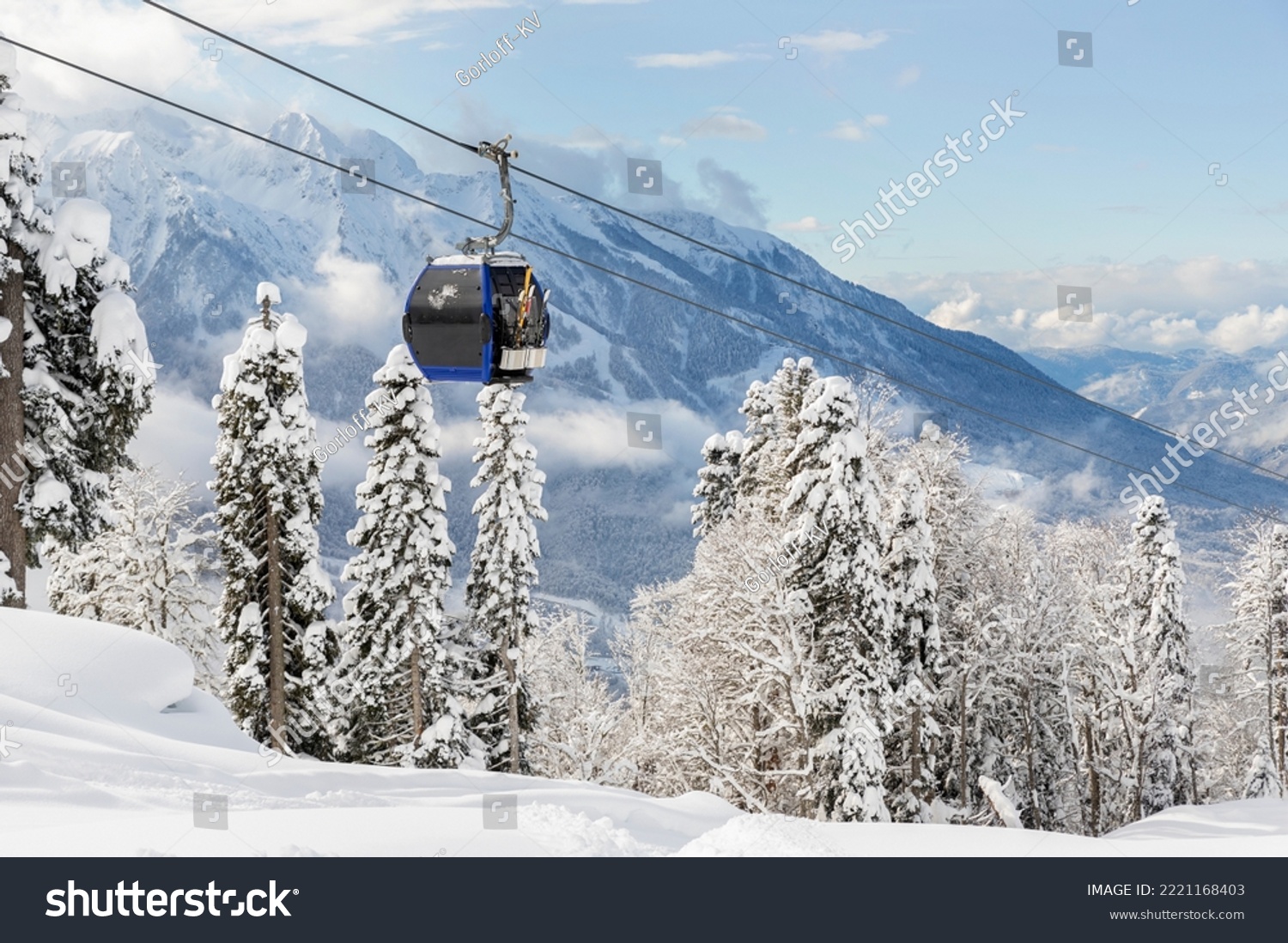 New modern spacious big cabin ski lift gondola against snowcapped forest tree and mountain peaks covered in snow landscape in luxury winter alpine resort. Winter leisure sports, recreation and travel #2221168403