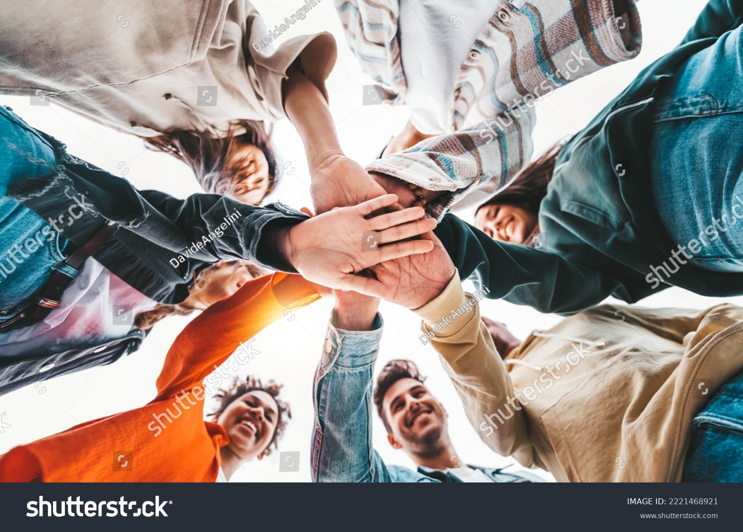 Community of young people stacking hands together - Multiracial college students putting their hands on top of each other - Human relationship, social, community and college concept #2221468921