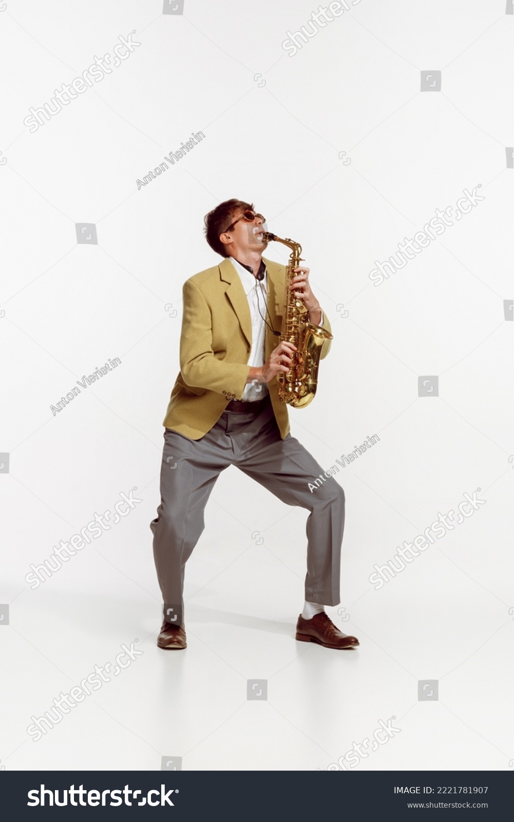 Portrait of young man in stylish yellow jacket playing saxophone isolated over white background. Jazz performer. Concept of live music, performance, retro style, creativity, artistic lifestyle #2221781907