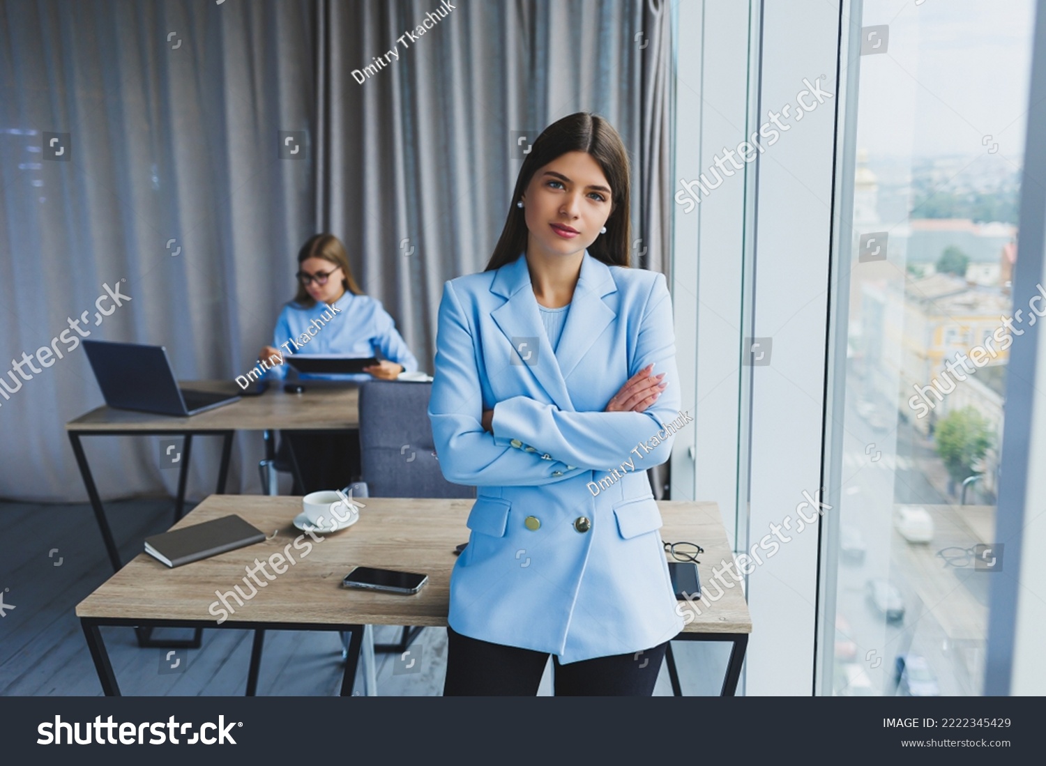 European businesswoman while working in the office. Young serious Millennial brunette woman in a jacket. The concept of freelance and remote work. Modern women's lifestyle #2222345429