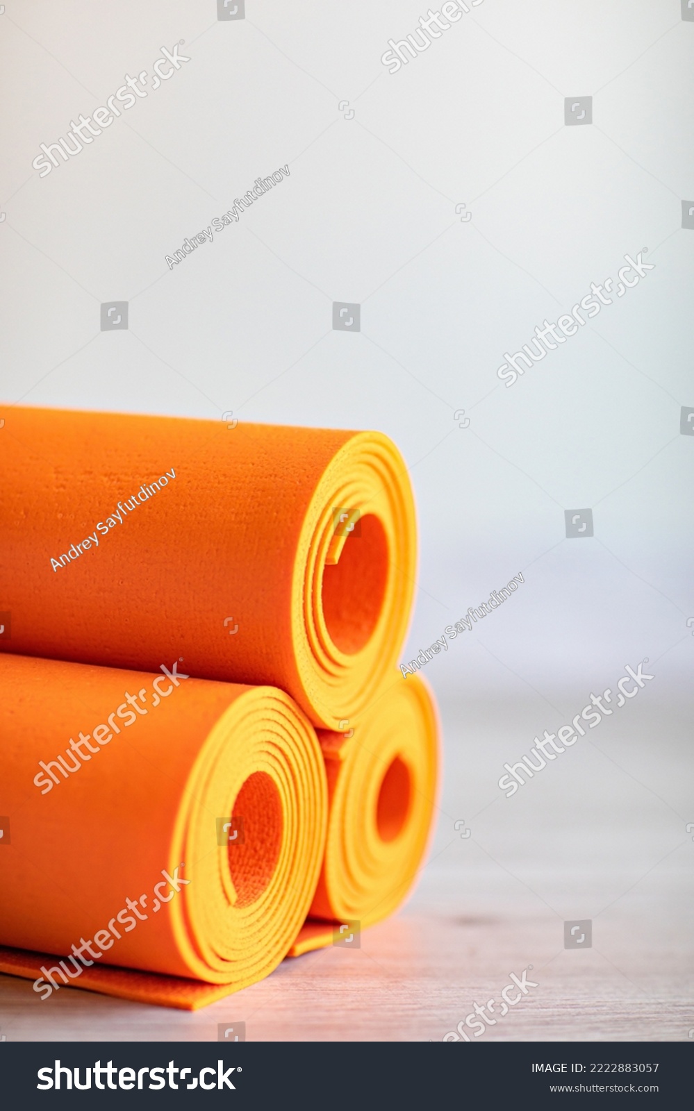 orange rolled up yoga and gymnastics mats on the floor. equipment for fitness and gyms and clubs. #2222883057