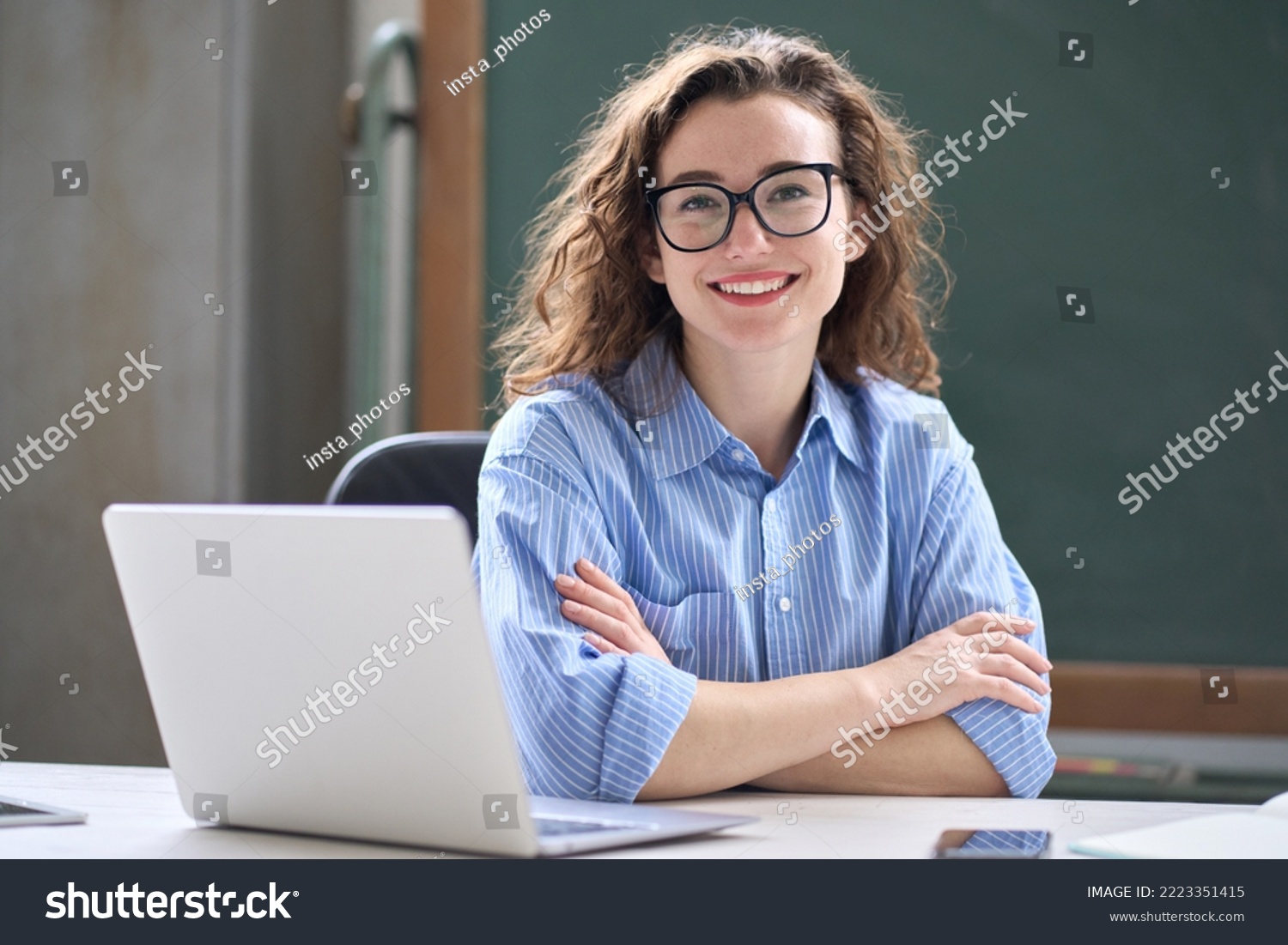 Young happy business woman sitting at work desk with laptop. Smiling school professional online teacher coach advertising virtual distance students classes teaching remote education webinars. Portrait #2223351415