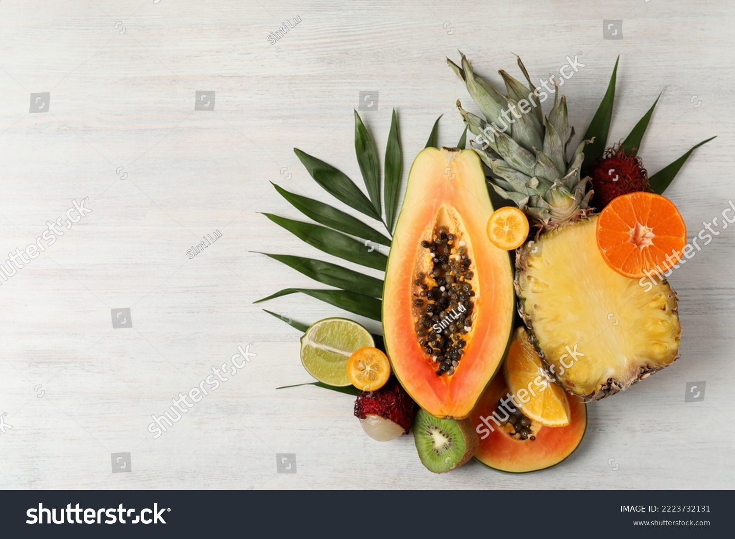 Exotic fruits on white wooden background, space for text. #2223732131