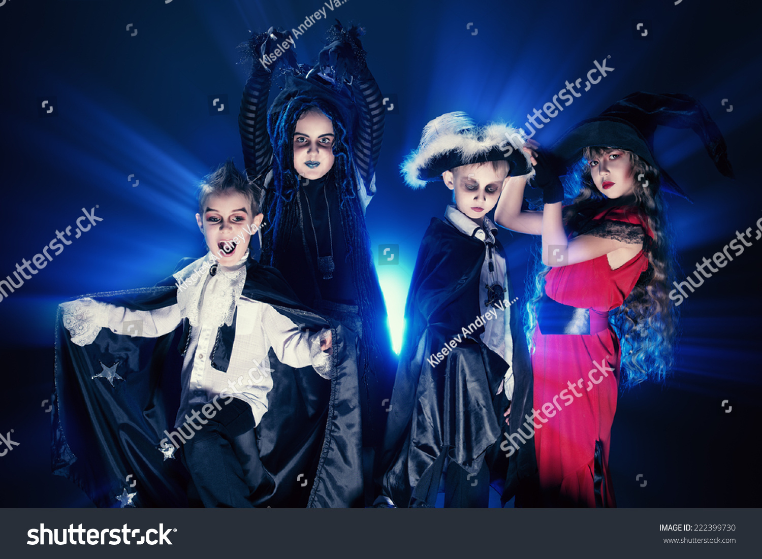 Cheerful children in halloween costumes posing over dark background. #222399730