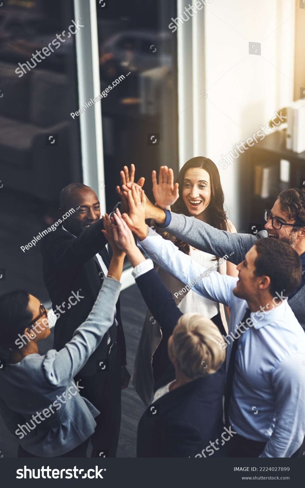Were going to succeed no matter what. Shot of a group of businesspeople high fiving in an office. #2224027899