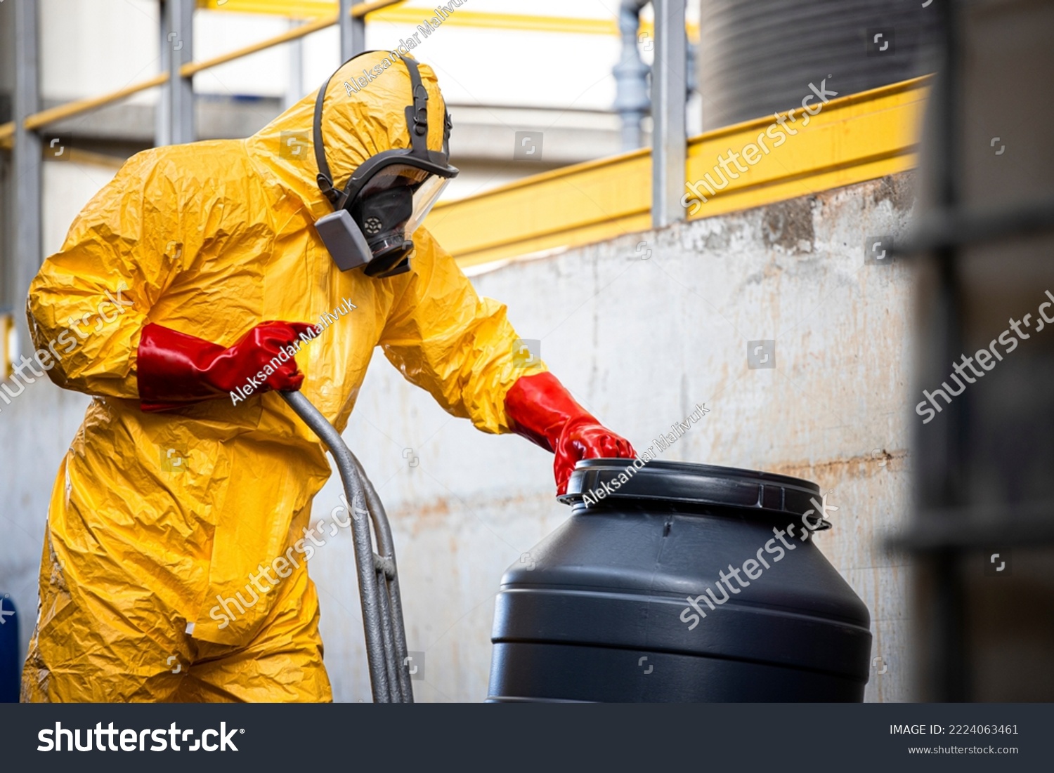 Chemical worker in protective suit and gas mask working with hazardous materials and toxic waste in production plant. #2224063461