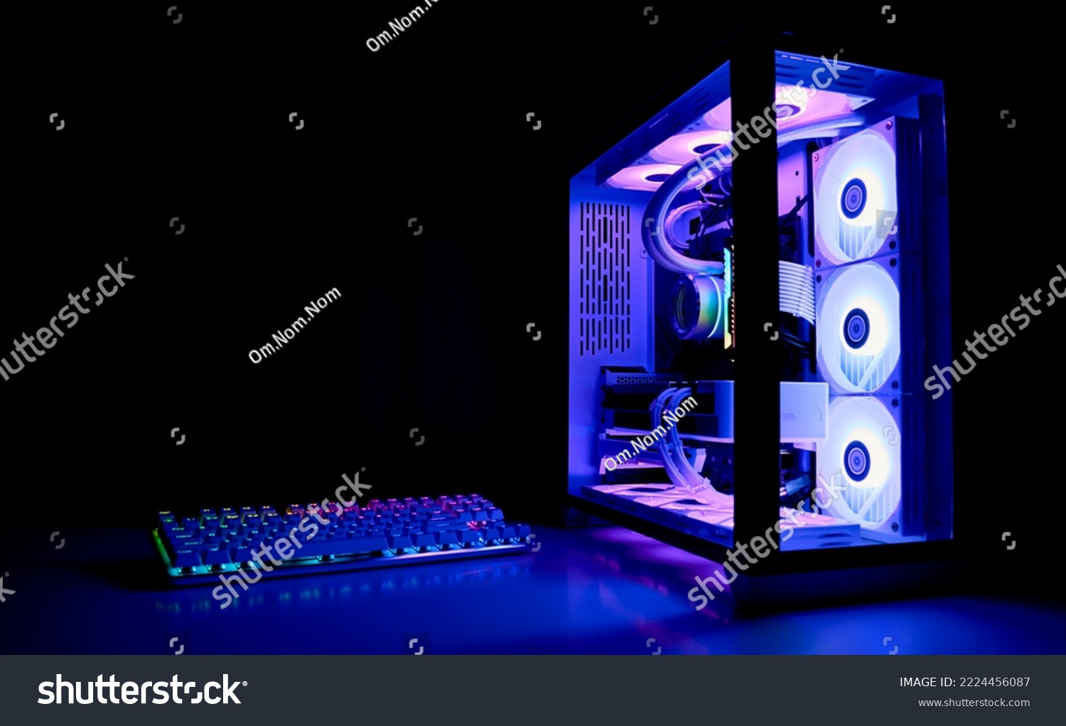Water Cooled Gaming Pc with RGB rainbow LED lighting. Modern gaming computer with a keyboard in a dark room. Water Liquid Cooling Computer #2224456087