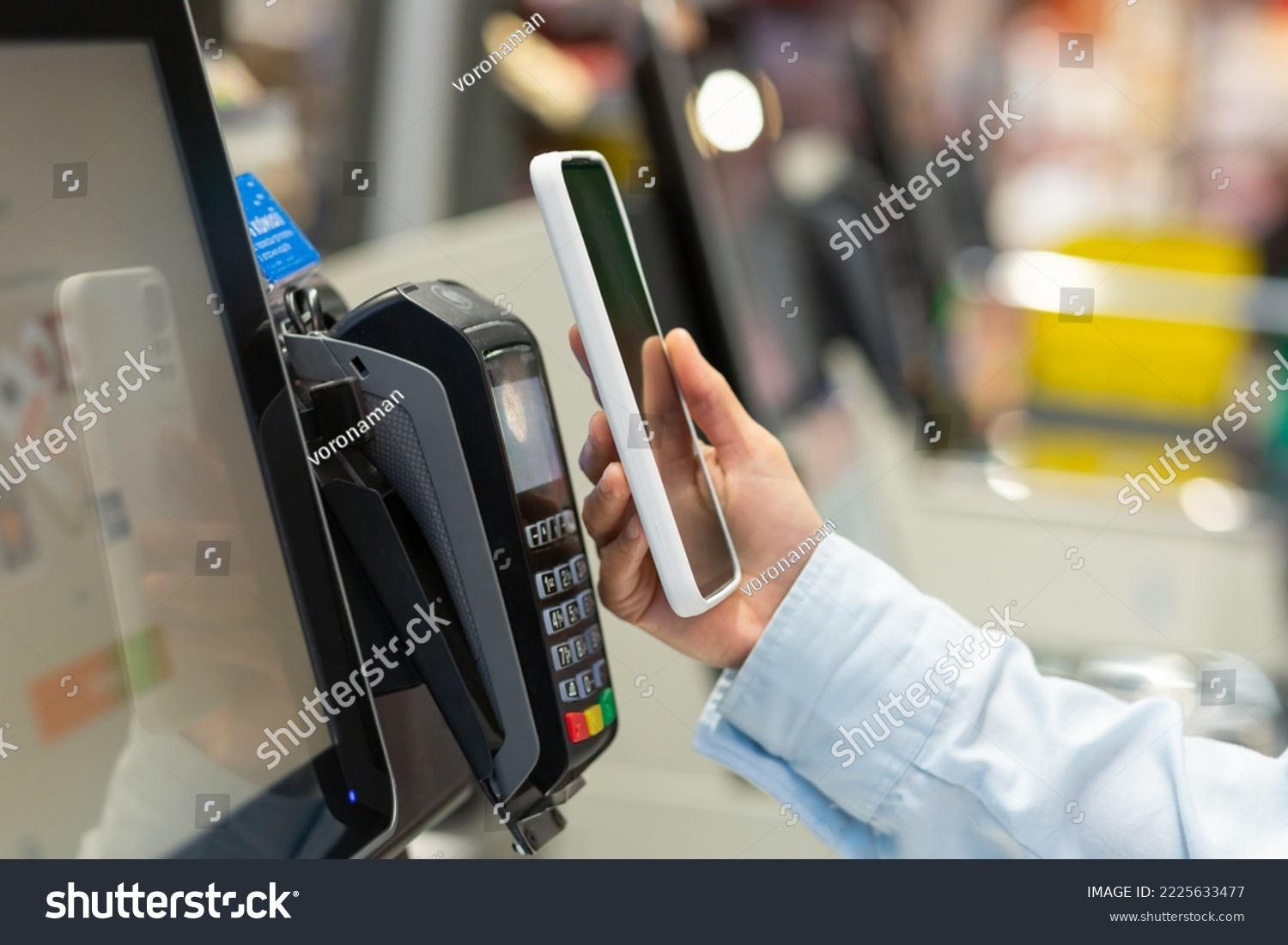 Closeup Woman Counter Buy electronic payment supermarket smartphone Female hand with a mobile phone in pay for purchases in stores Contactless NFC Terminal Closeup card reader. #2225633477