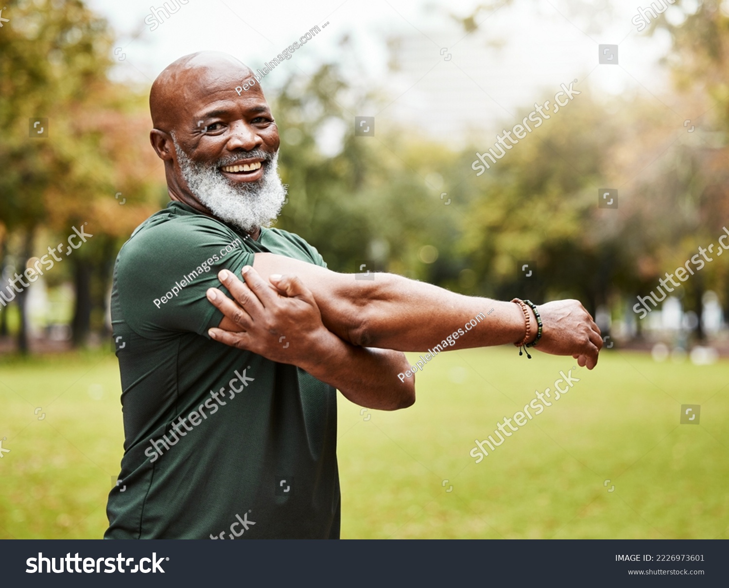 Senior fitness, exercise and black man stretching outdoor at park for energy, health and wellness in retirement. Portrait, face and smile of male in nature for workout, cardio and training in summer #2226973601