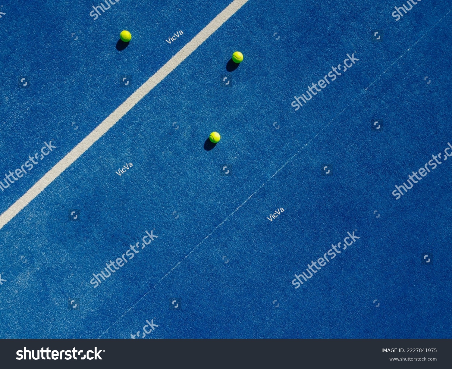 Overhead aerial view of three balls near the net of a blue paddle tennis court, sports courts #2227841975