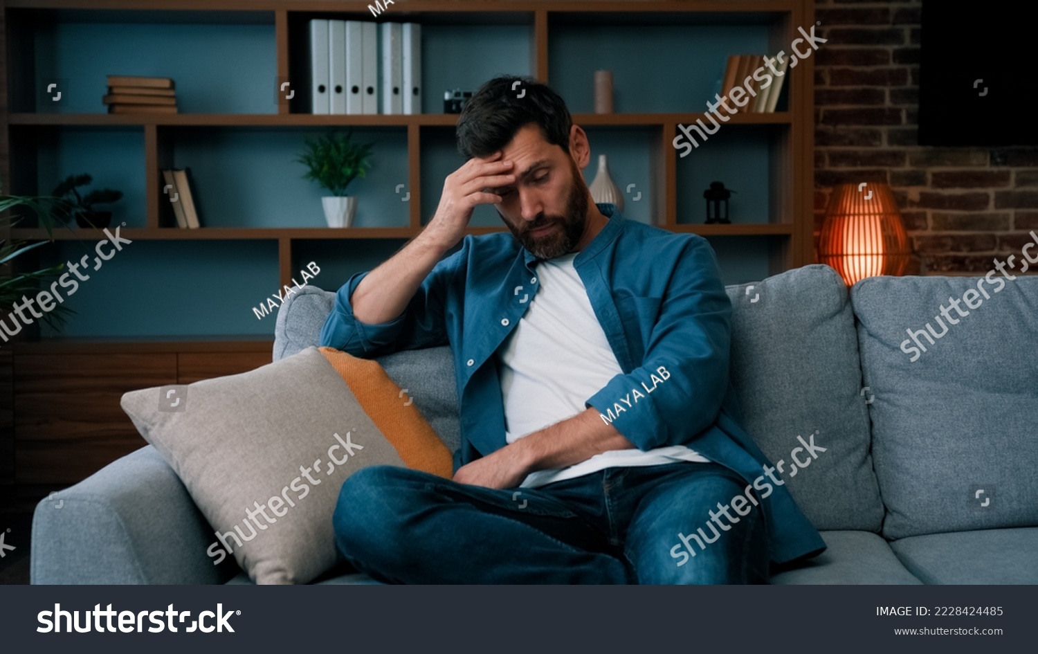 Tired upset father caucasian bearded man sit on sofa frustrated about hard working day at home stressed worried single guy lonely male irritated anxious feel unwell exhaistion lack of energy stress #2228424485