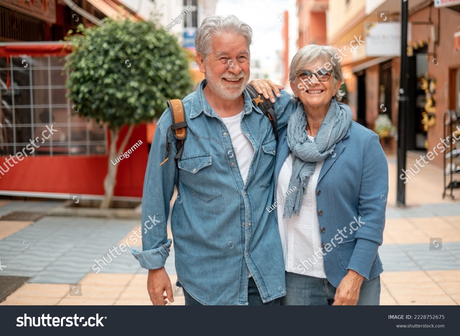 Happy smiling senior couple of tourist walking in the city. Attractive white haired caucasian people enjoying free time or retirement #2228752675