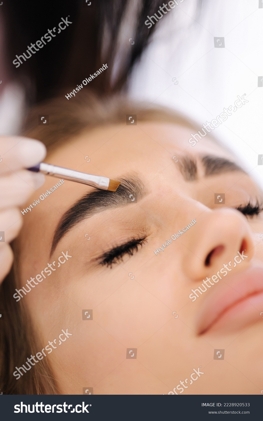 Brow master applies henna on eyebrows for beautiful blond hair woman. Fashion slyle #2228920533