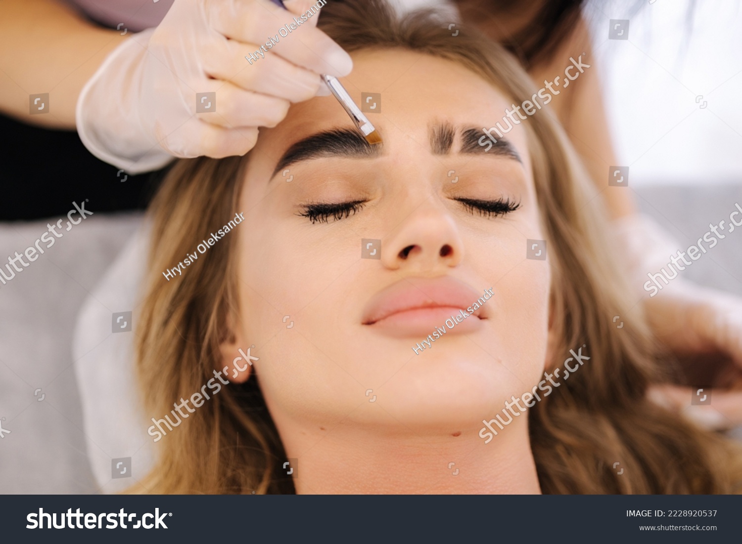 Brow master applies henna on eyebrows for beautiful blond hair woman. Fashion slyle #2228920537