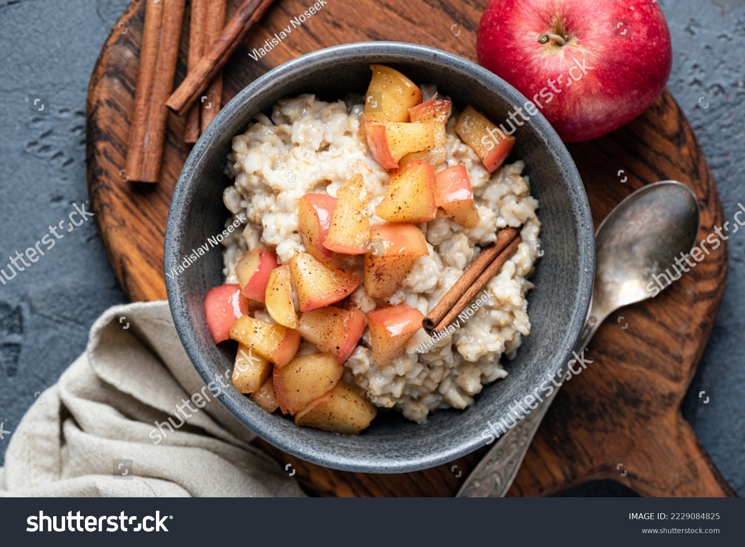 Oatmeal porridge with apple and cinnamon in bowl, top view. Healthy breakfast meal #2229084825