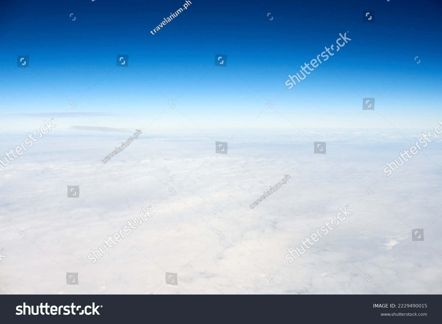Over clouds aerial top view from aircraft window, thick white blue clouds looks like soft foam, overcast with fresh frosty air. Beautiful cloudy sky view to troposphere, heavy cloudiness #2229490015