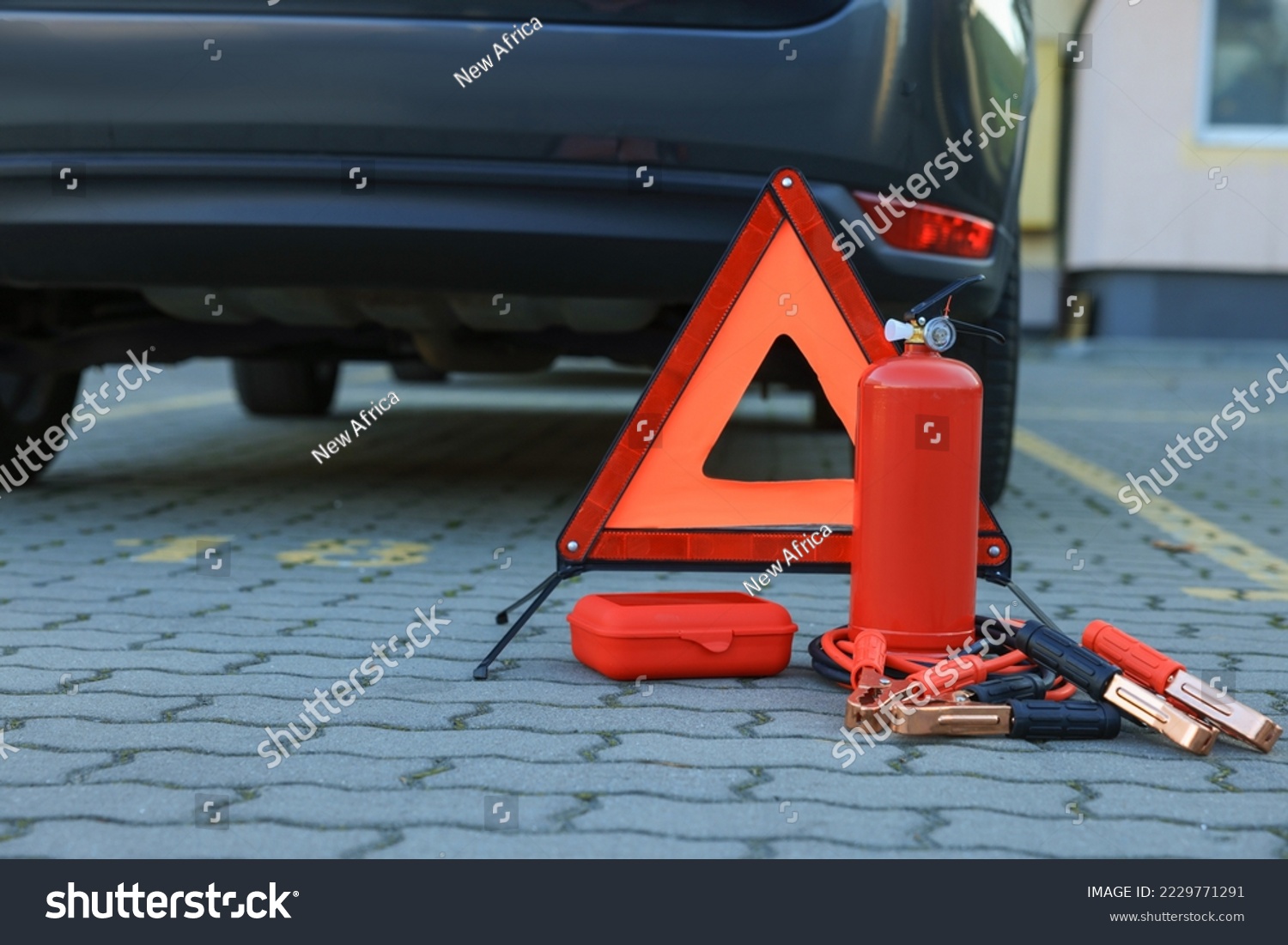 Emergency warning triangle and safety equipment near car, space for text #2229771291